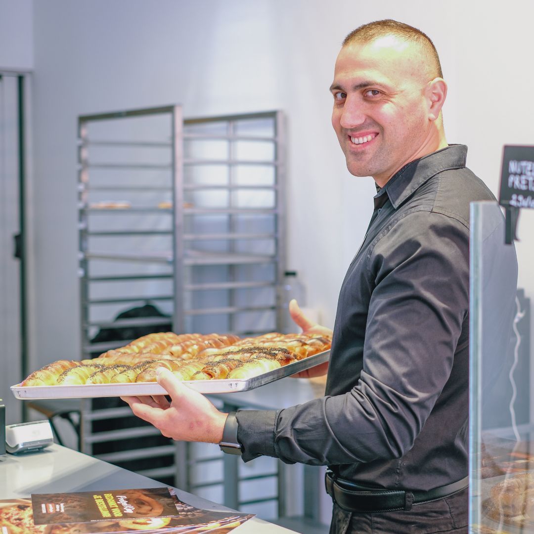 Een bakker van Pretzel King presenteert een schaal versgebakken pretzels